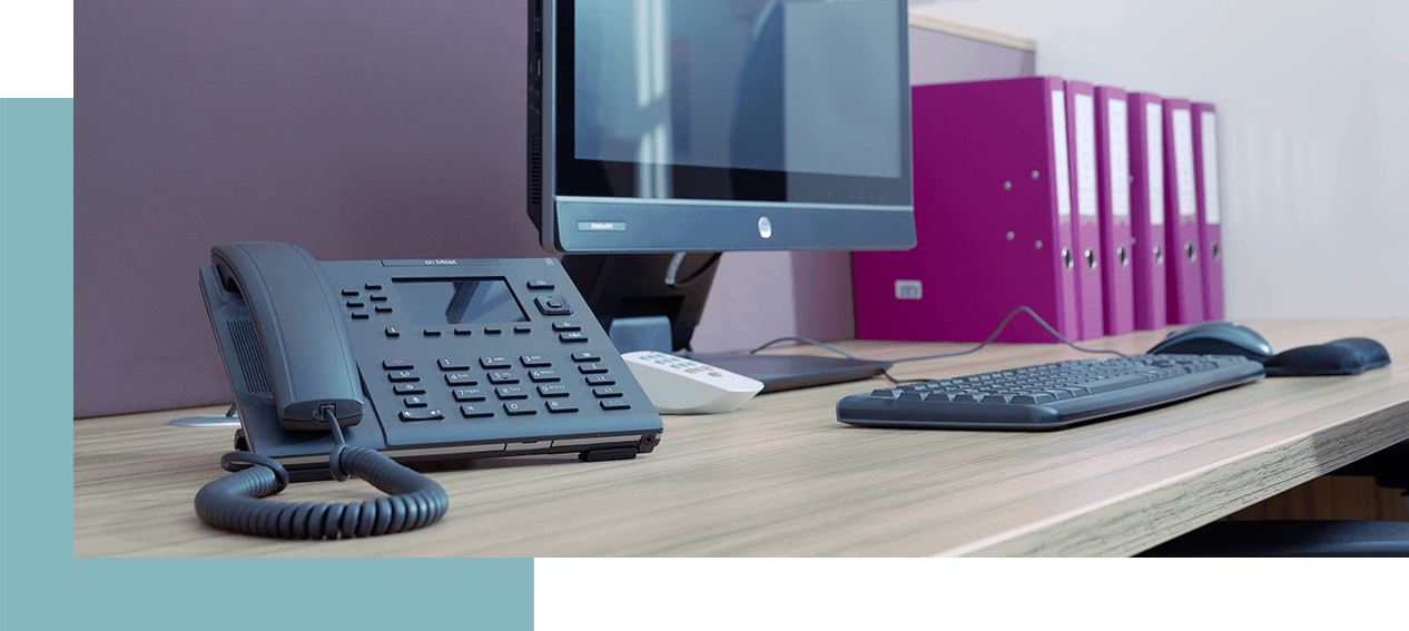 Kontakt - Schreibtisch mit Telefon, Bildschirm und Aktenordner